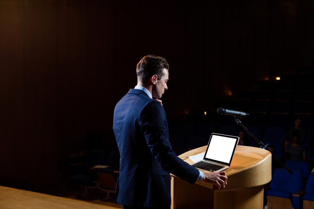 male business executive giving a speech at conference center